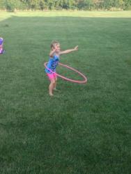 young child hula hoops on lawn