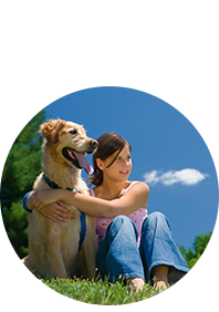 Girl sitting and hugging her dog in lawn after flea control in Boynton Beach