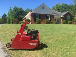 Red color machine in lawn during lawn aeration in Edgewater Park