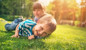 kids playing on grass treated by springtime lawn care in Rhode Island