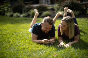Couple laying in grass after Lawn Doctor provided Residential Lawn Care in Everett