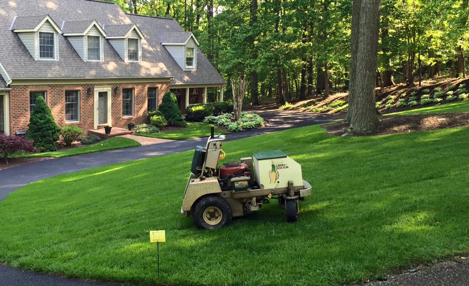 lawn machine in action power seeding over front yard showing lawn care in Carroll County