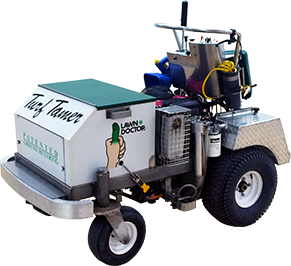 Machine on wheels labeled Turf Tamer Post image Machine on wheels labeled Turf Tamer