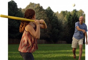 Father and daughter playing ball on a green lawn with trees in background showing lawn weed control in Harrison