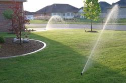 Sprinklers watering front lawn showing lawn services in Hudsonville