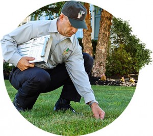 expert with clipboard stoops down to provide Lawn Care Service in Porter