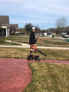Man blowing off sidewalk after yard work