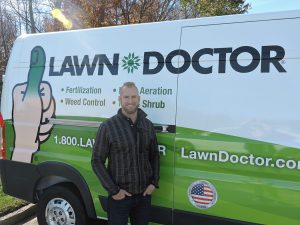 lawn doctor owner in front of his lawn care service cedar park truck 
