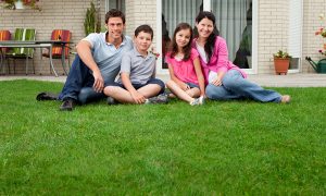 family sitting on green grass