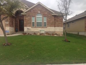 beautifully cared for lawn in front of brick house showing lawn aeration in new braunfels