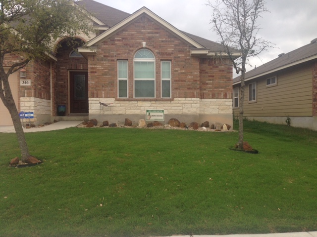 beautifully cared for lawn in front of brick house showing weed control in New Braunfels