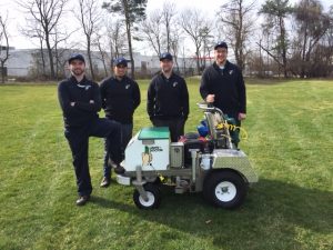 four employees in front of lawn doctor power seeder