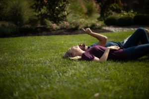 Couple laying on Green grass after Lawn Doctor provided Grass Care in Totowa