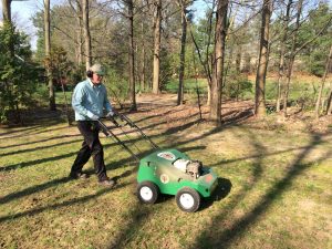 man aerating a yard with a power seeder