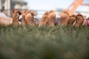 People laying in green grass after Lawn Doctor provided Lawn Care in Lindale