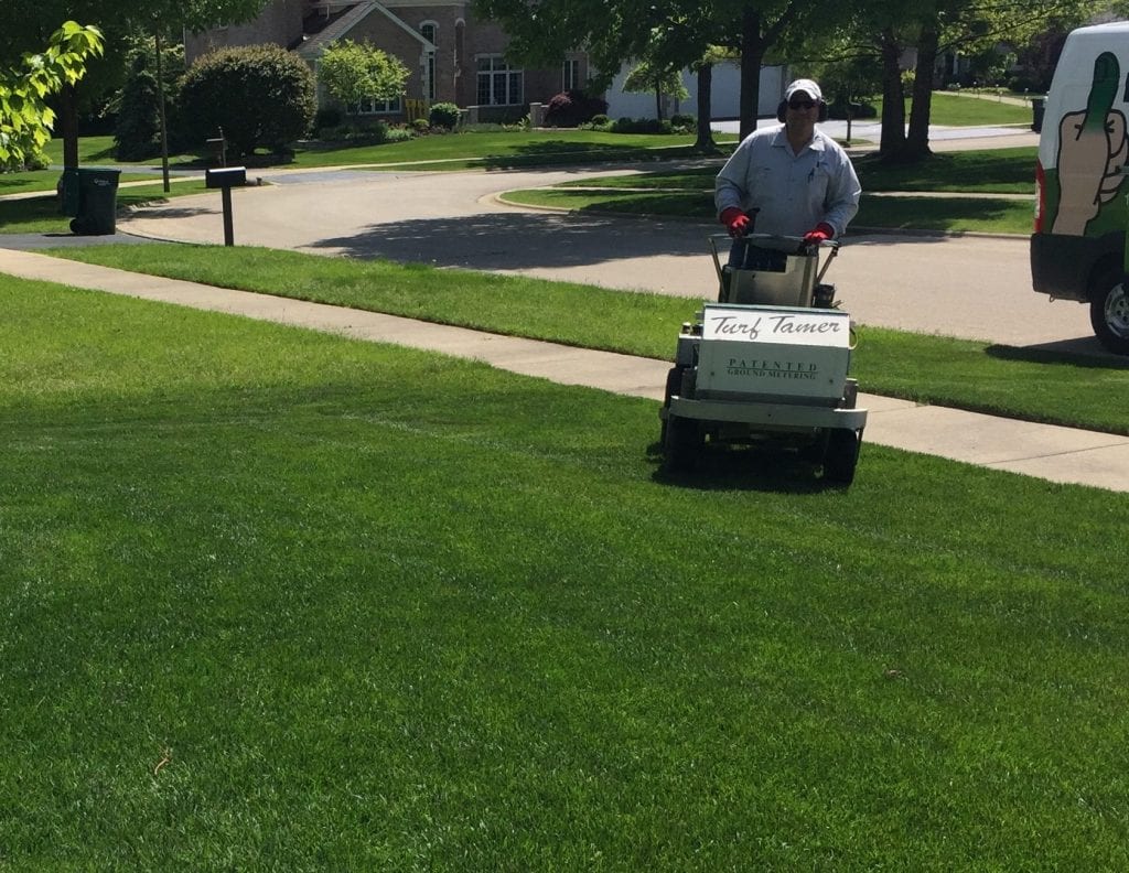 Technician with fertilizer on lawn